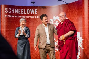 Laudatorin Thinlay Chukki (Repräsentantin des Dalai Lama in Genf) applaudiert den Vertretern des Tibet Film Festivals Lobsang Dhondup (Mitte) und Golog Jigme (rechts). Foto: Tanja Brückner